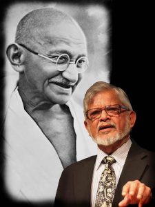 Arun Gandhi stands in front of a poster of his grandfather.  Credit: Submitted