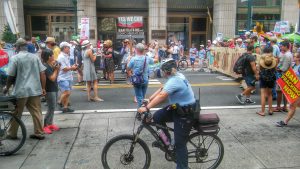 A police officer on a bike watches over protesters Sunday. Credit: Tom Sofield/NewtownPANow.com