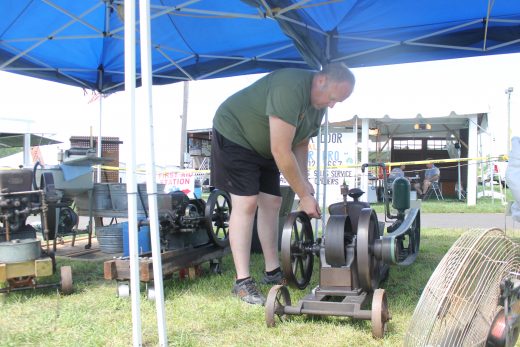 A man oils an old pieces of equipment on display. Credit: Tom Sofield/NewtownPANow.com