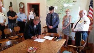 The mayor signs documents to confirm the officer's new position.  Credit: Newtown Borough Police