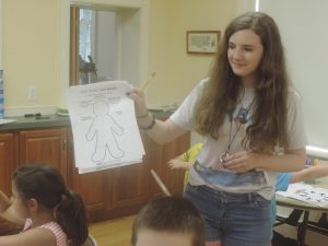 Counselor Lucia Miller teaches campers about an emotional being to be filled out with words about the children’s emotions. Credit: Petra Chesner Schlatter